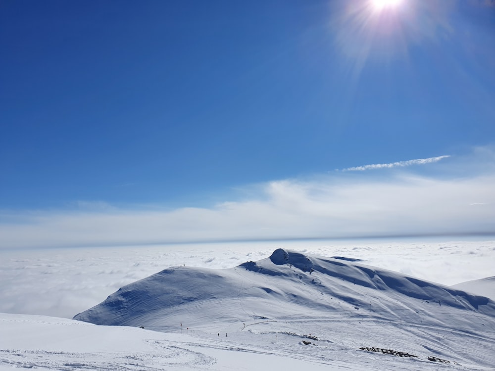 the sun is shining over a snowy mountain