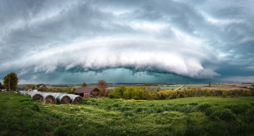 a large storm rolls in over a green field