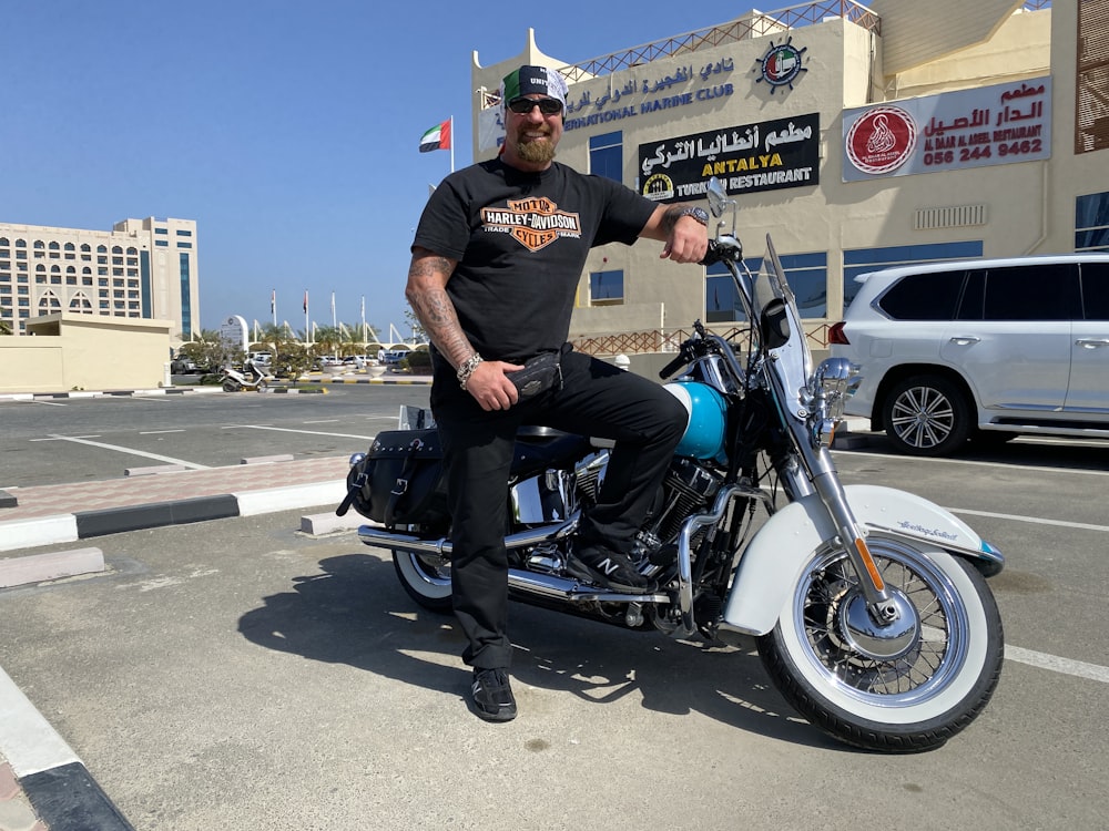 a man sitting on a motorcycle in a parking lot