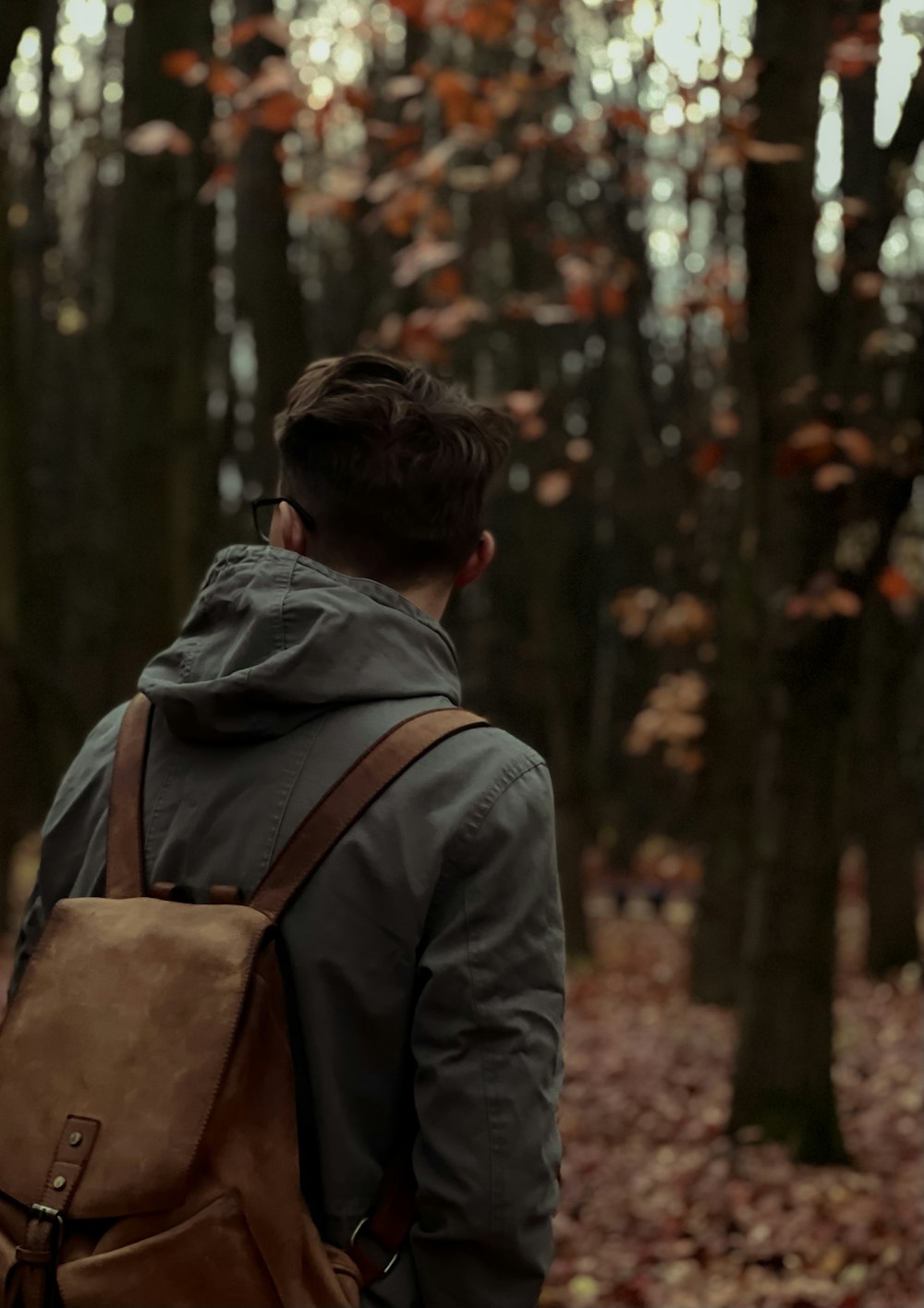 a man with a backpack walking through a forest