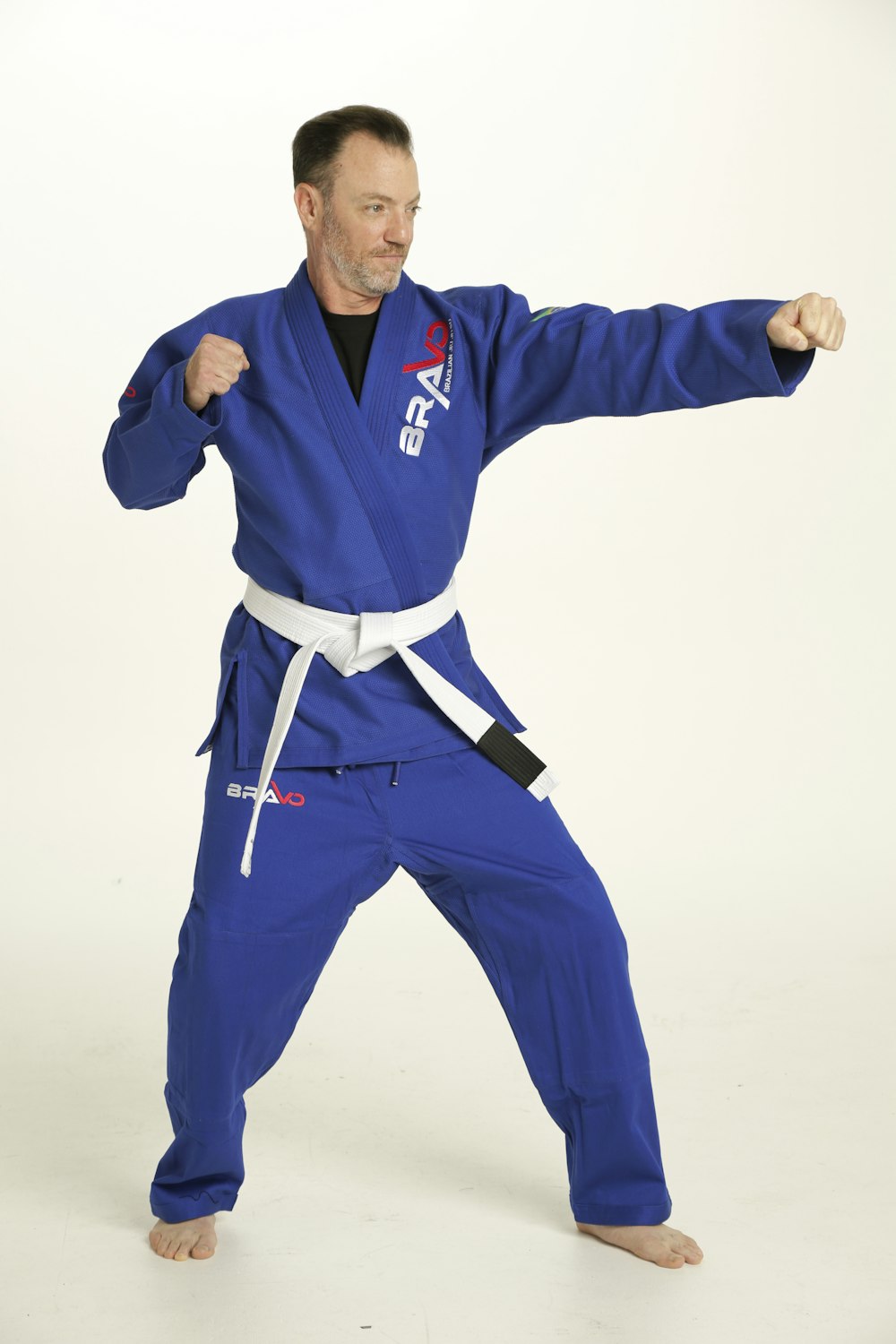 Un uomo in una tuta blu di karate è in posa per una foto