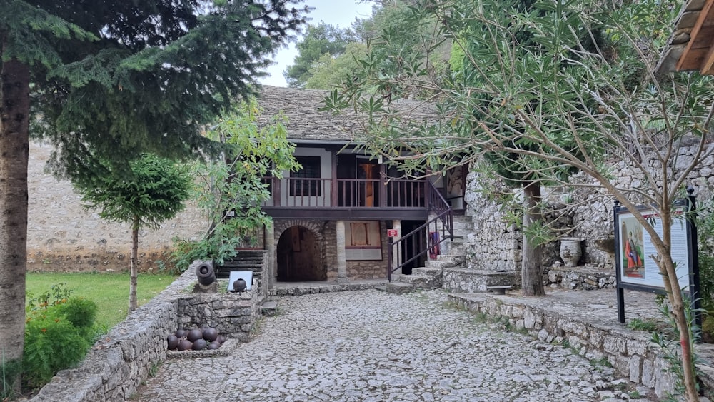 a stone building with a balcony next to trees