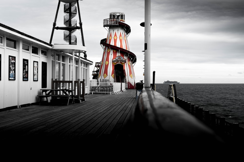 a pier with a lighthouse next to the ocean