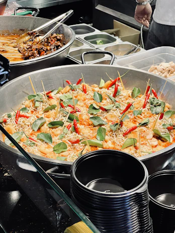 A steaming pot filled with vibrant Italian pasta and colorful Chinese stir-fry ingredients.