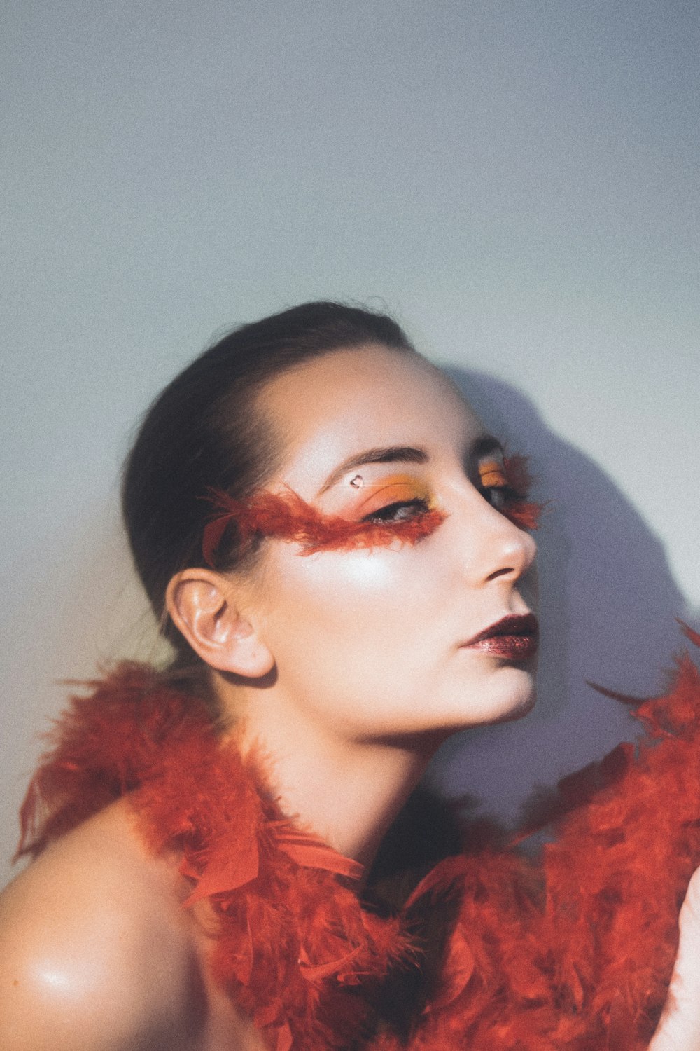 a woman with red feathers around her neck