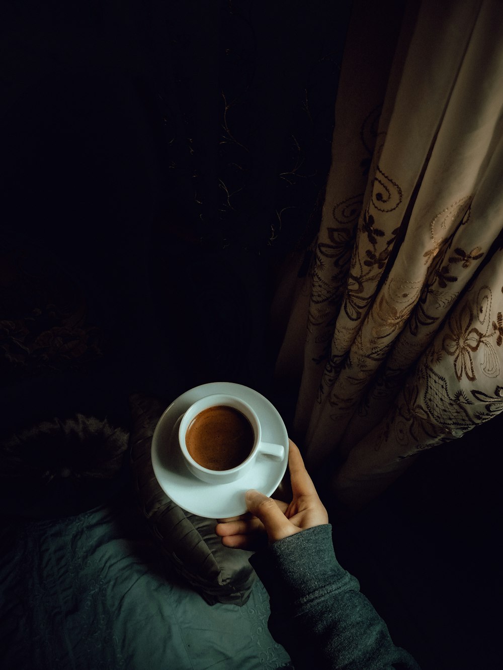 a person holding a cup of coffee in their hand