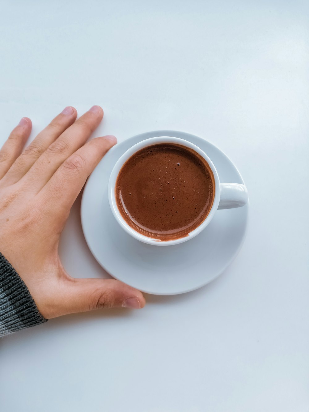 a person holding a cup of hot chocolate