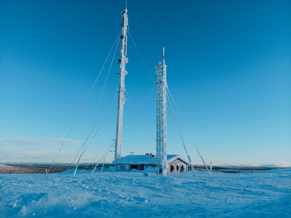 a couple of cell towers sitting on top of a snow covered field