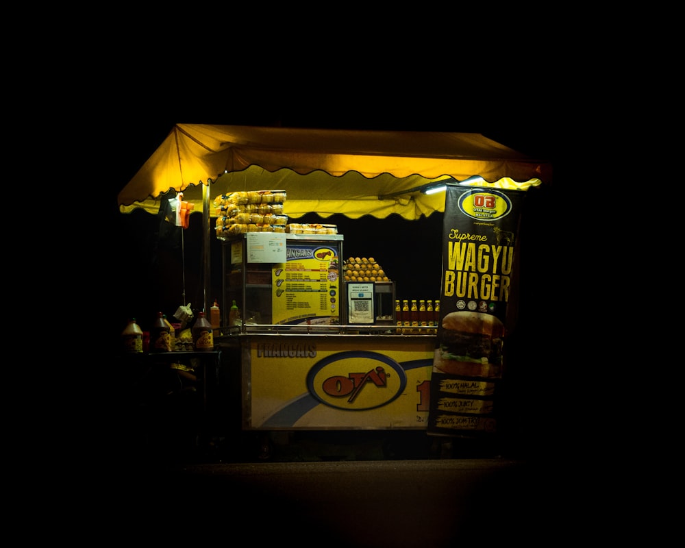 a food stand lit up at night in the dark