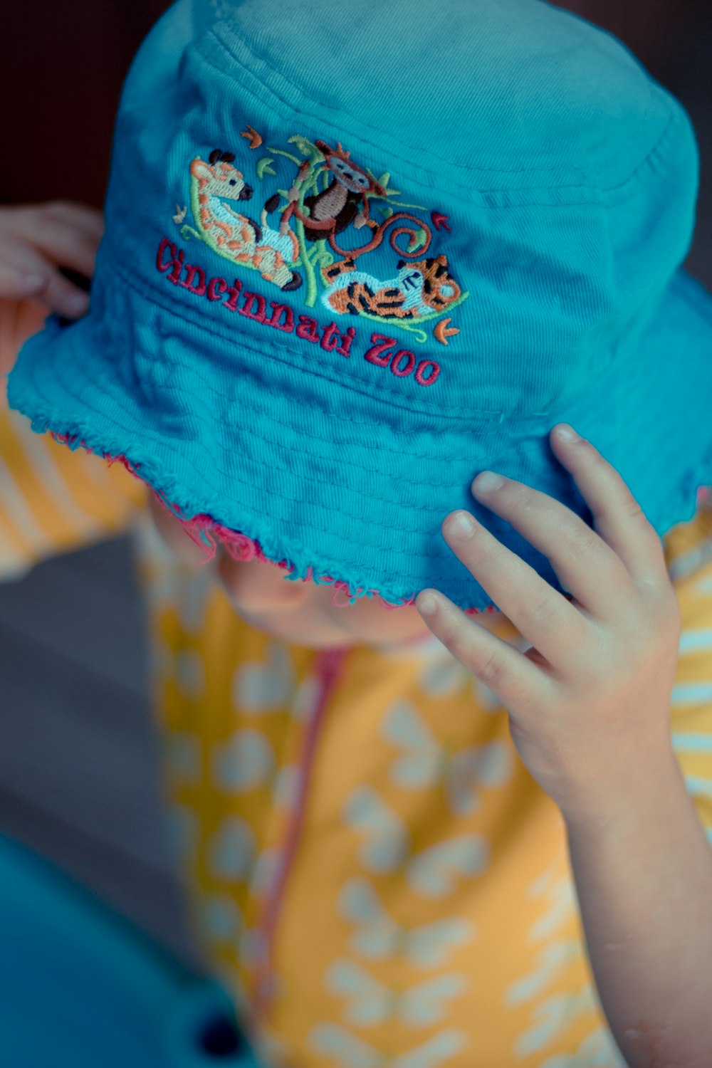 a child wearing a blue hat with mickey mouse on it