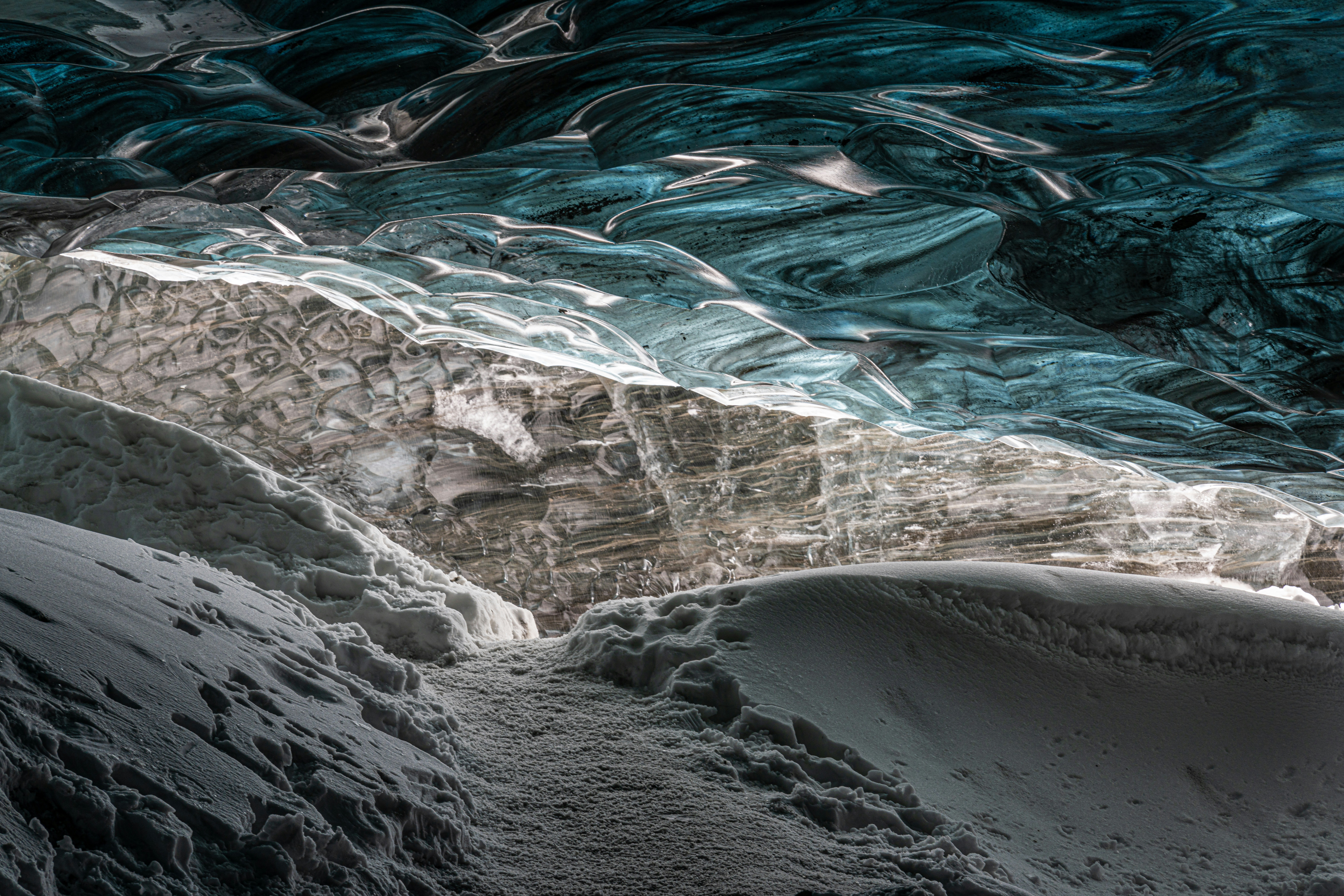 a large ice cave with snow on the ground