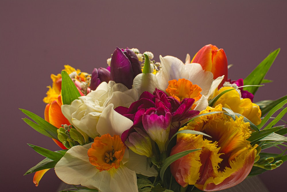 a vase filled with lots of different colored flowers