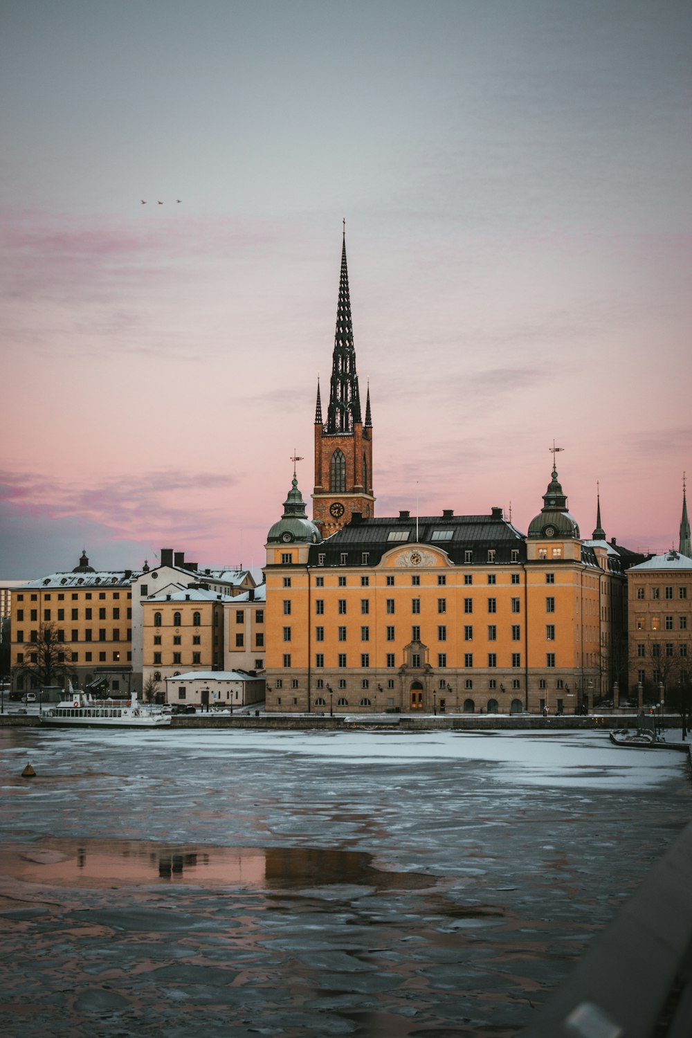 a large building with a tower next to a body of water