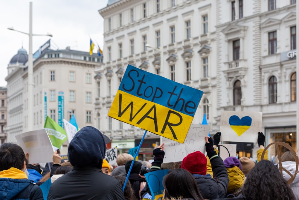 a group of people holding up signs in front of a building