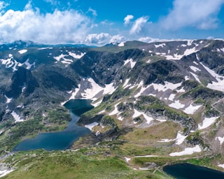 an aerial view of a mountain range with a lake in the foreground