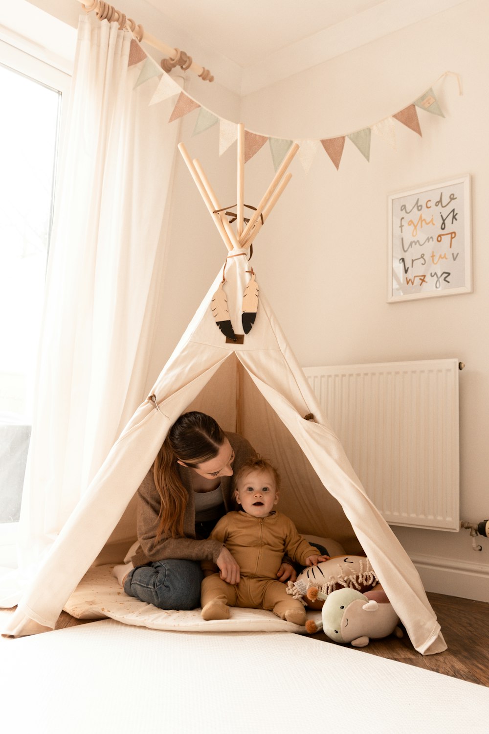 a woman and a child sitting in a teepee