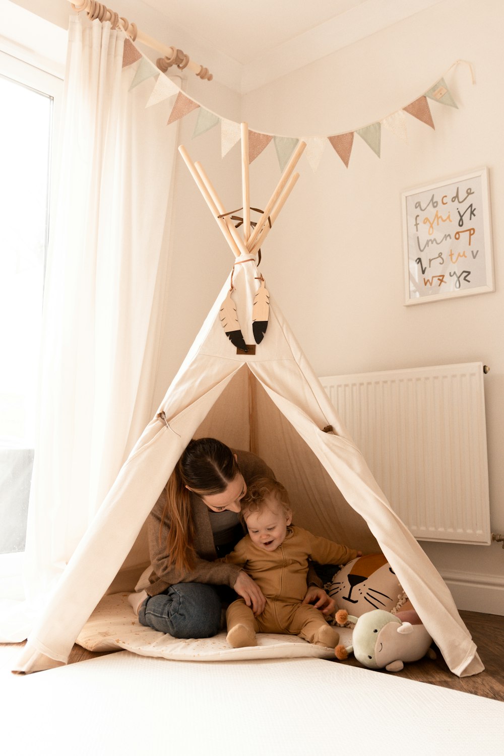 a woman and a child sitting in a teepee