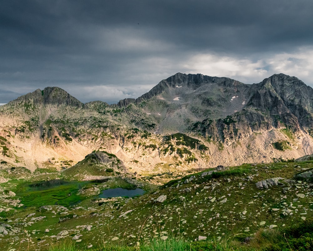 uma vista de uma cordilheira com um lago em primeiro plano