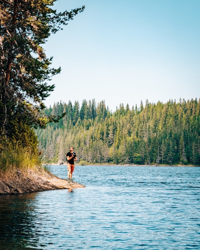 a person standing on a rock in the middle of a lake