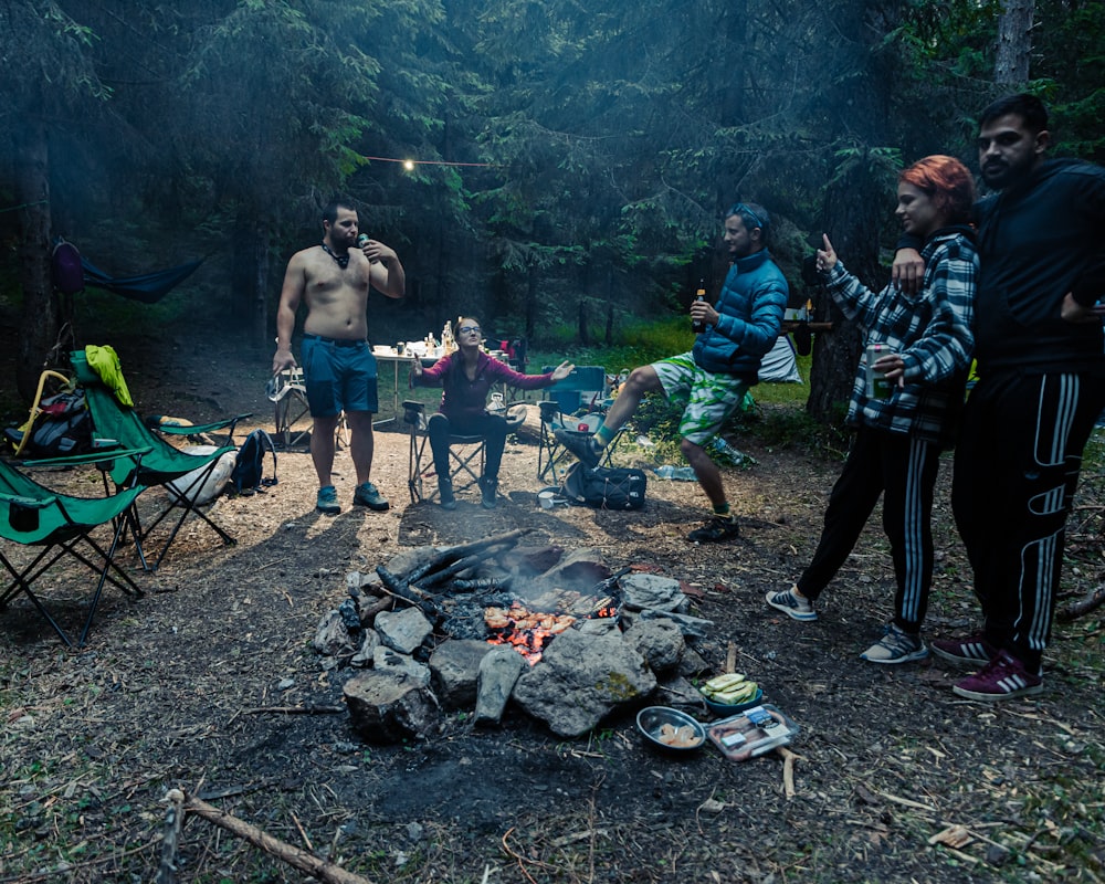 a group of people standing around a campfire