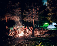 a group of people sitting around a campfire