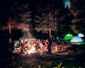 a group of people sitting around a campfire