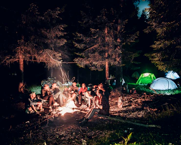 a group of people sitting around a campfire