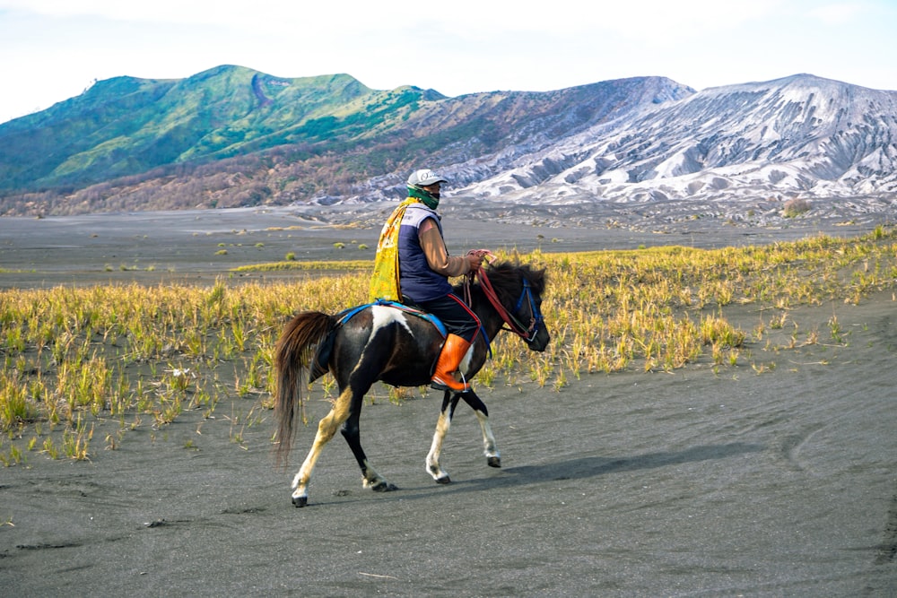 a man riding on the back of a brown horse