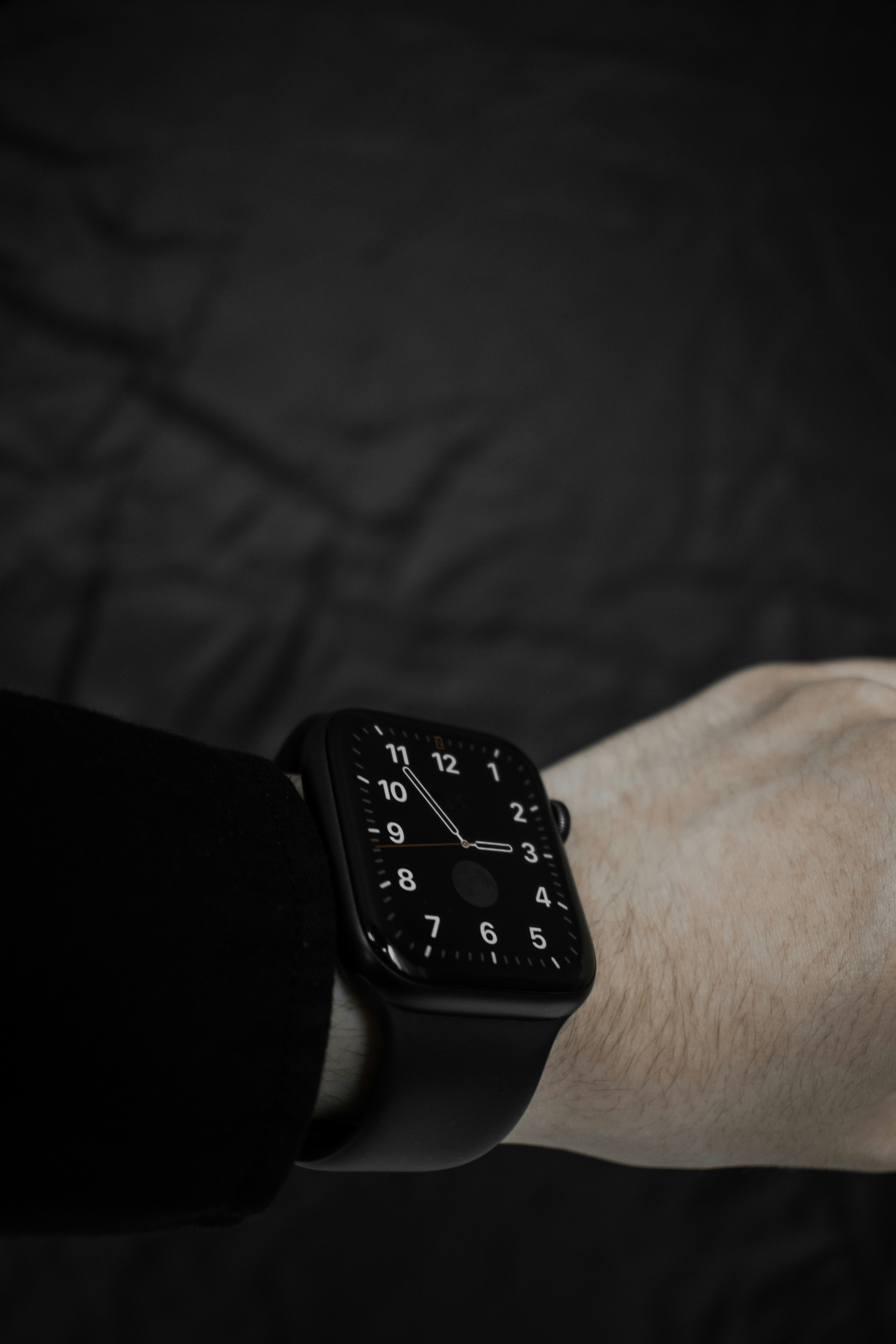 Apple Watch con cinturino sport nero appoggiato su carta stropicciata scura, quadrante che mostra le 15:09