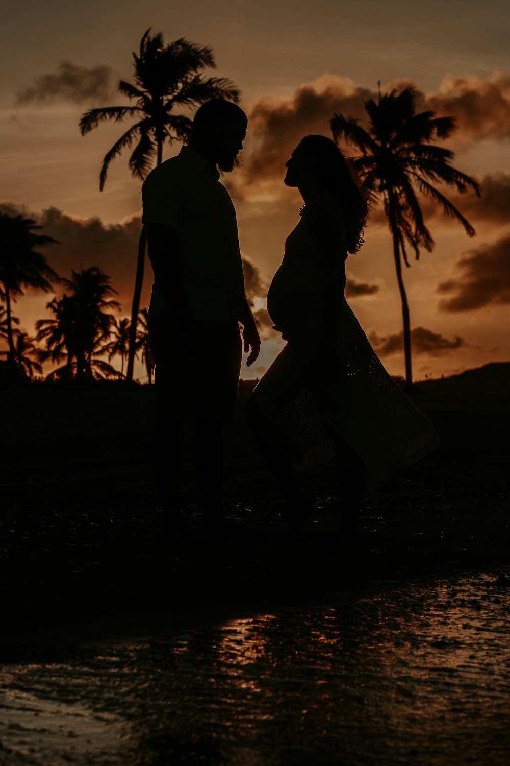 a man and a woman standing next to a body of water