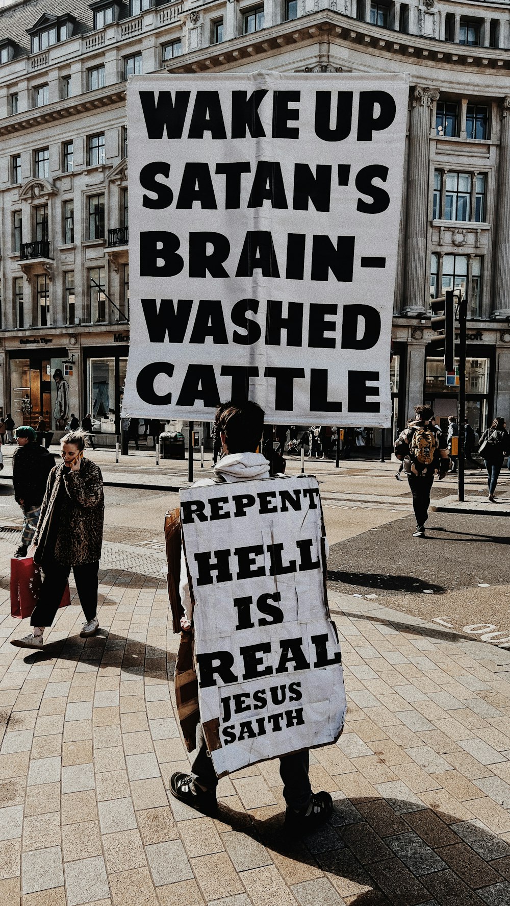 a group of people walking down a street next to a sign