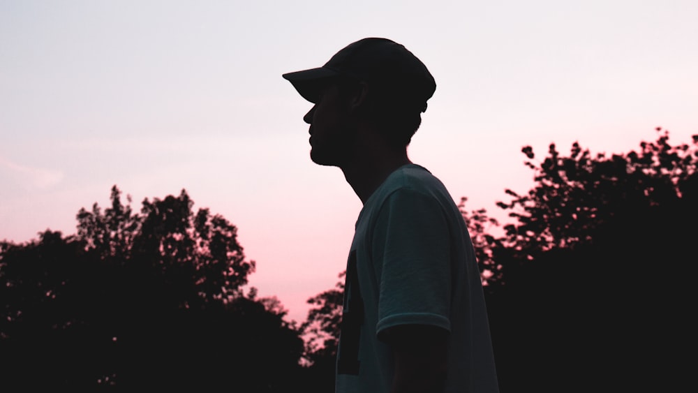 a silhouette of a man wearing a hat