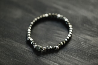a beaded bracelet on a black surface