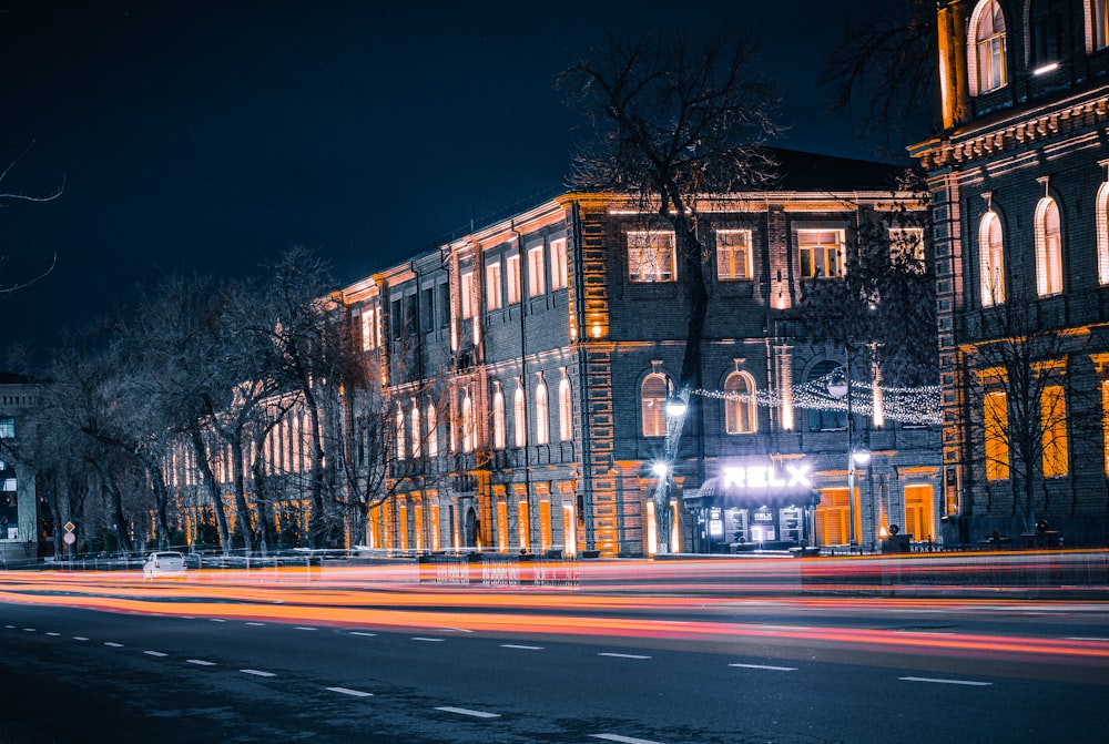 a city street at night with a building lit up