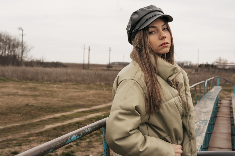 a woman standing next to a metal rail