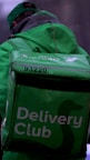 a person in a green jacket carrying a delivery bag