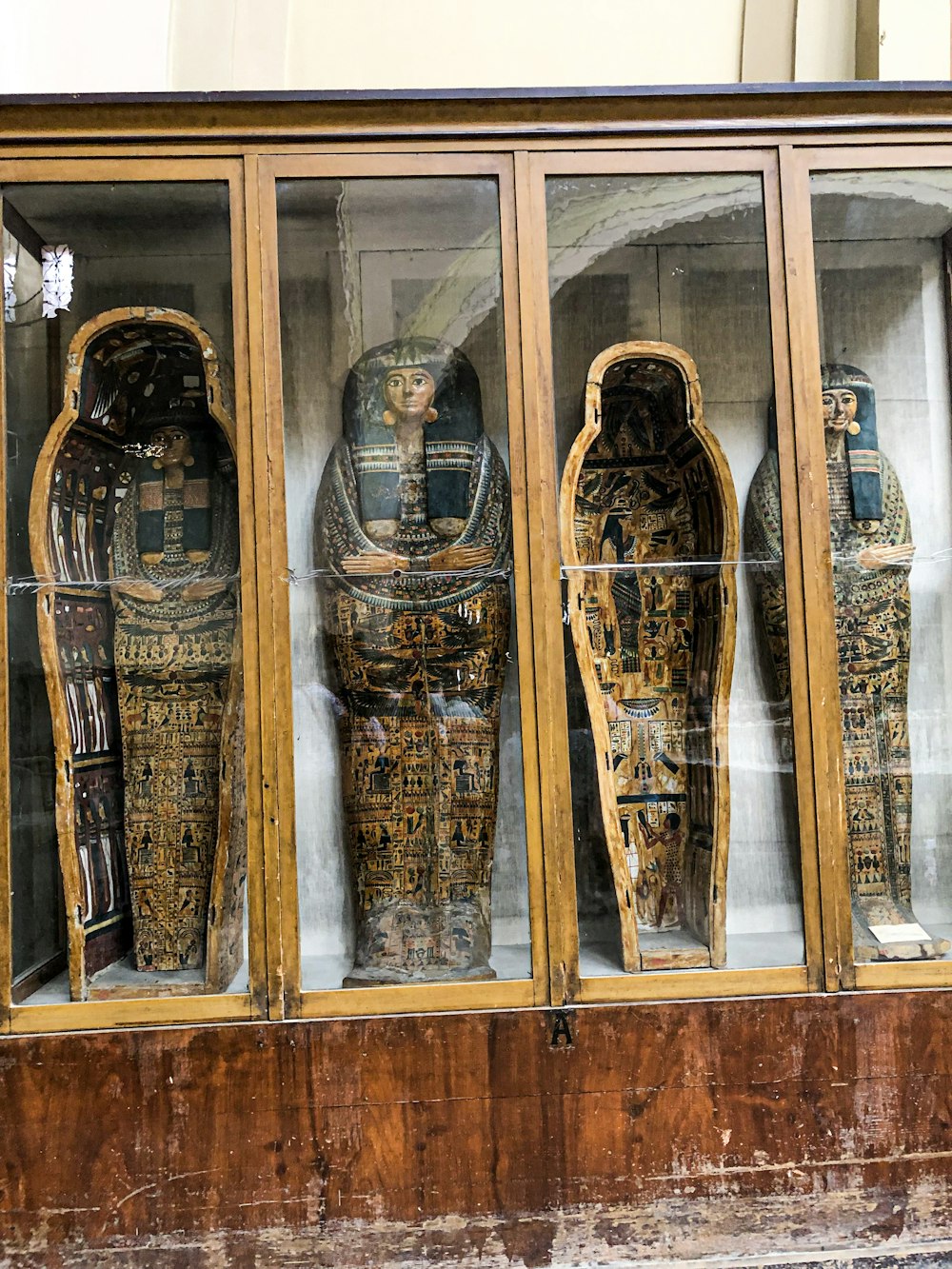 a group of carved wooden figures in a display case