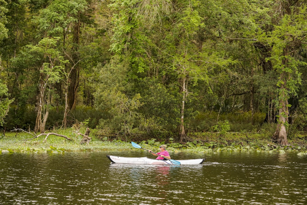a person in a canoe paddling on a river