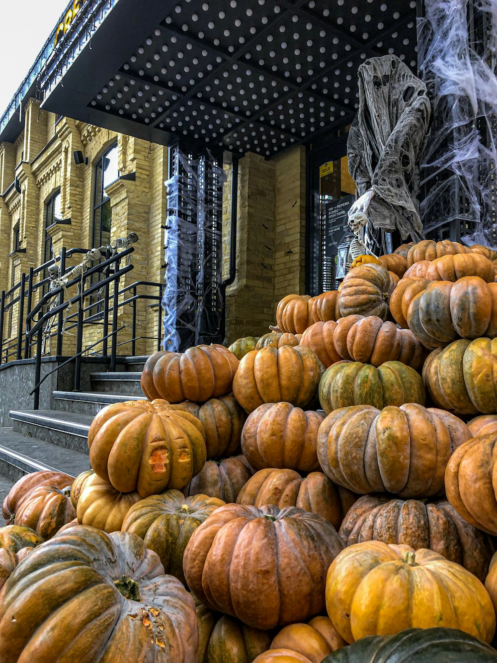 a pile of pumpkins sitting outside of a building