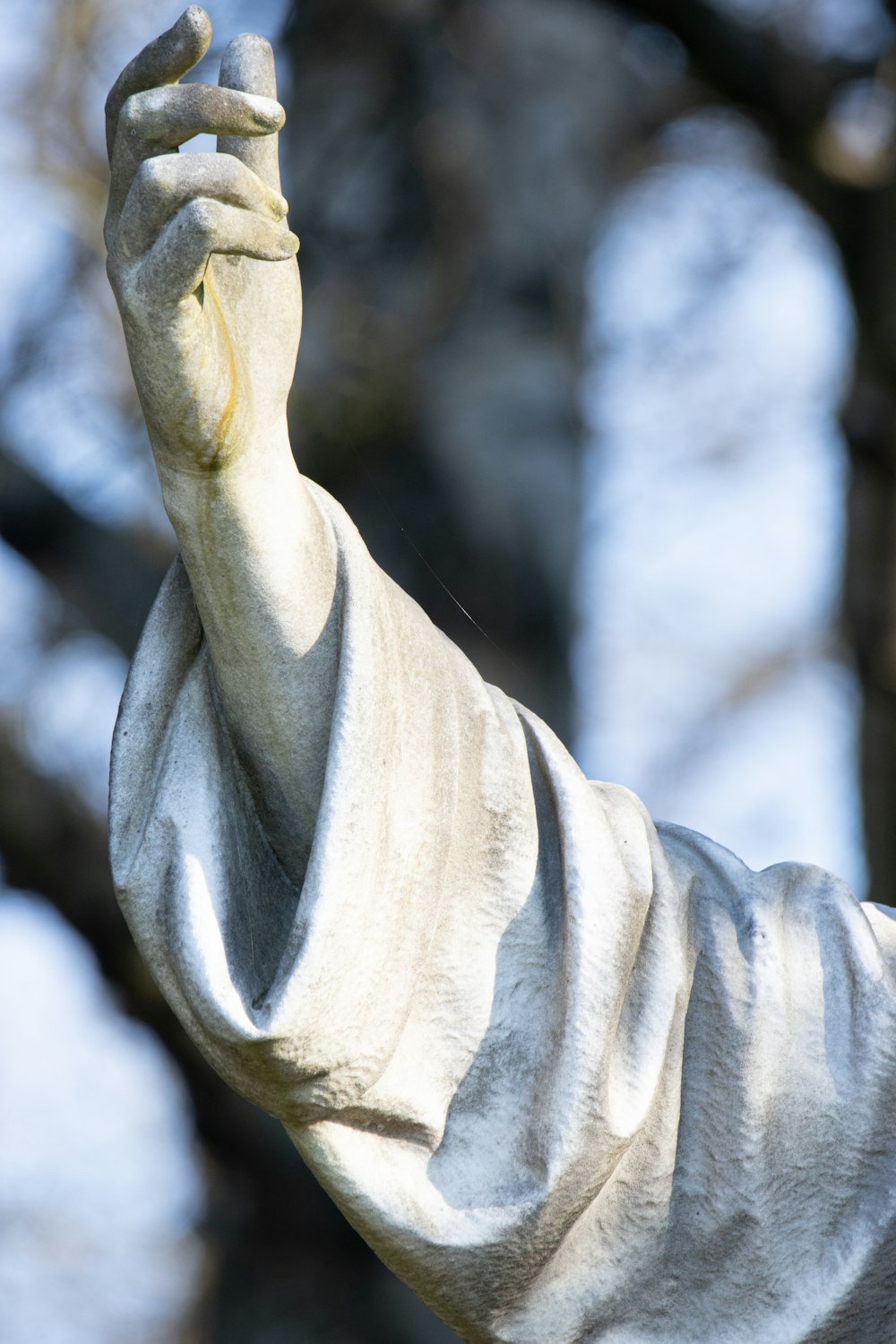 a close up of a statue of a person holding a cell phone