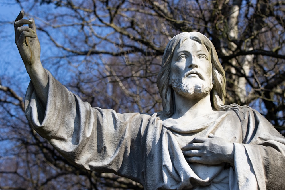 a statue of jesus holding a bird in his hand
