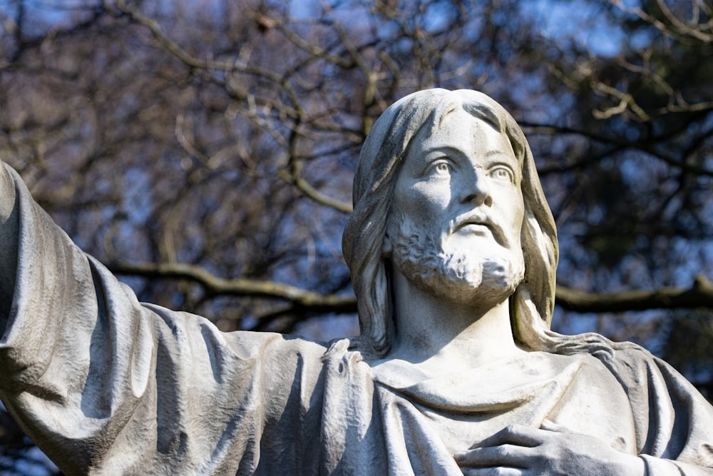 uma estátua de Jesus segurando as mãos no ar