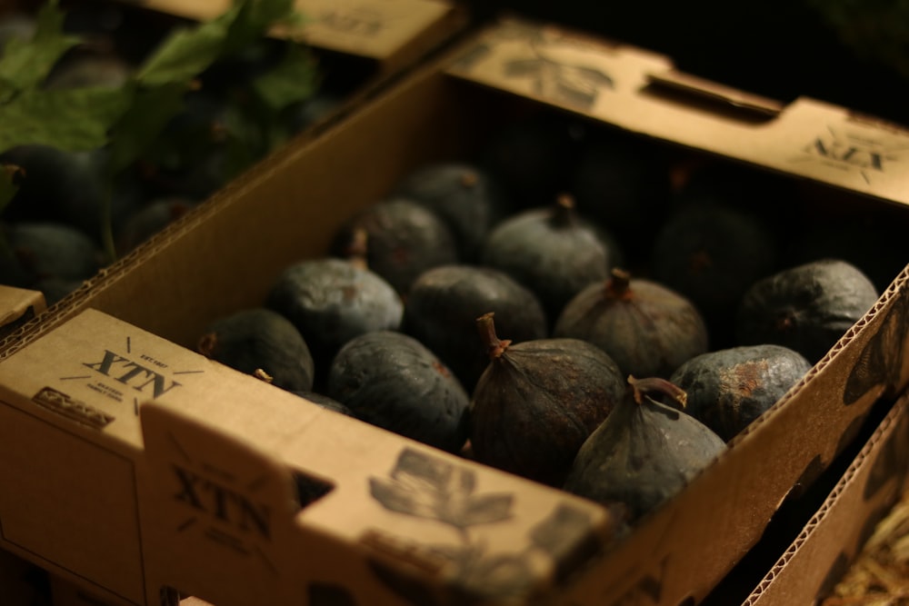 a box filled with lots of ripe figs