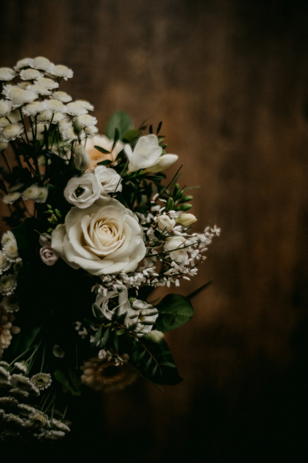 a bouquet of white flowers sitting on top of a wooden table