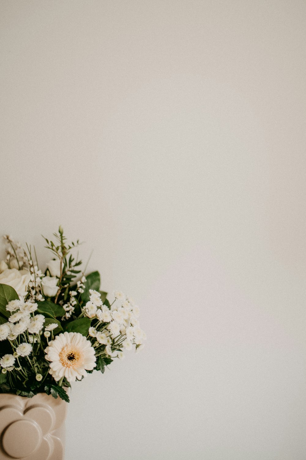 a vase filled with white flowers on top of a table