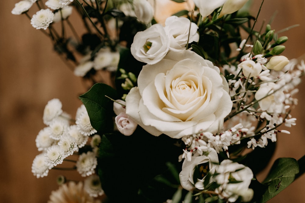 a bouquet of white flowers sitting on top of a wooden table