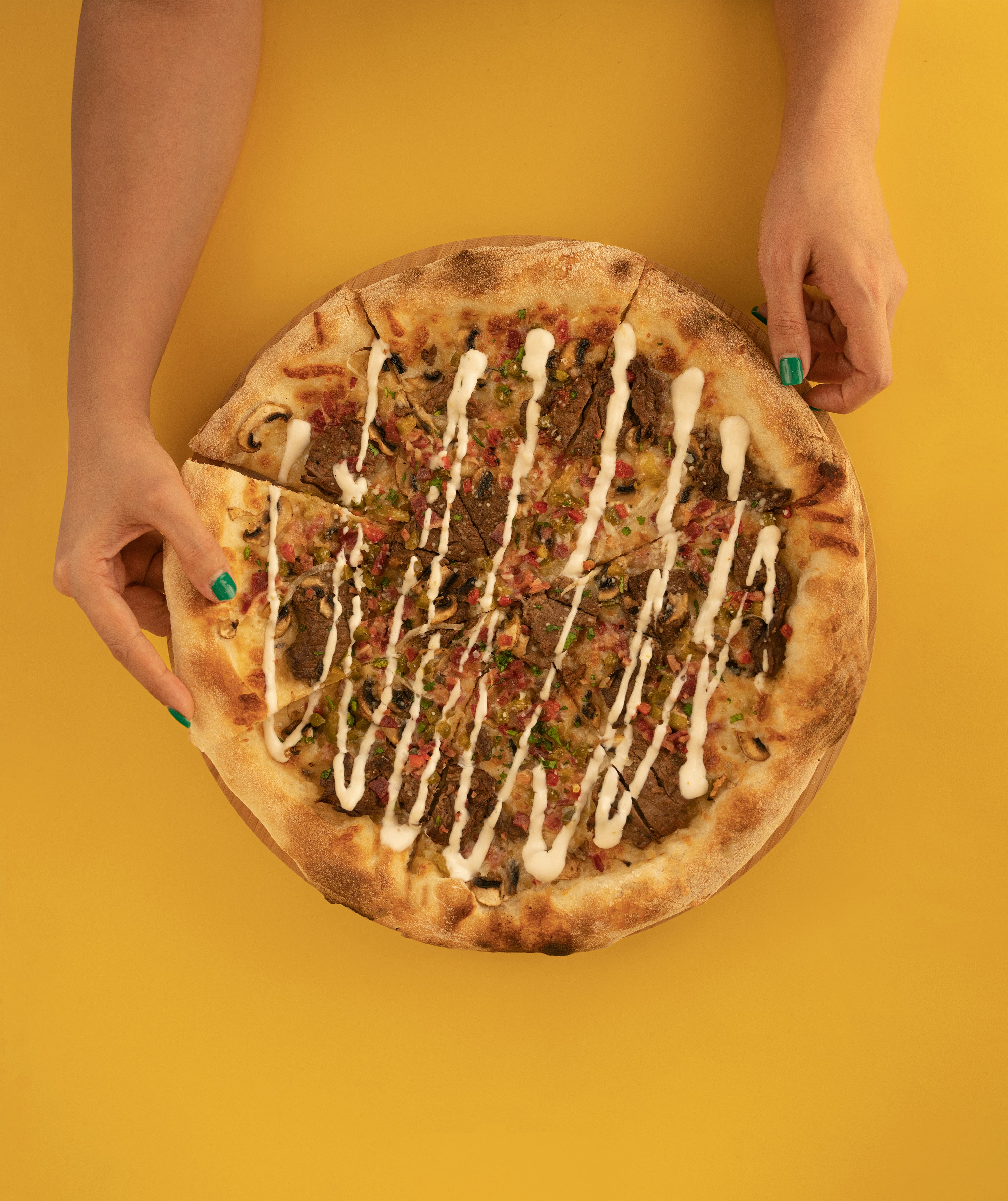 a person holding a pizza with toppings on it