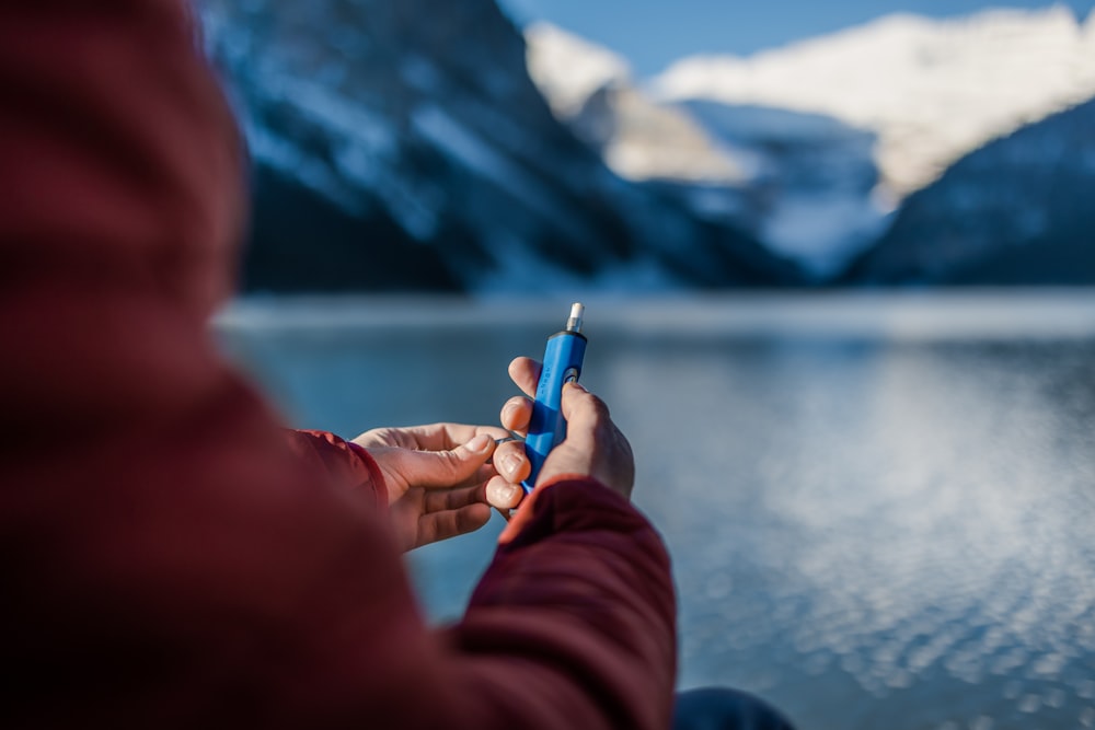 una persona sosteniendo un objeto azul en la mano