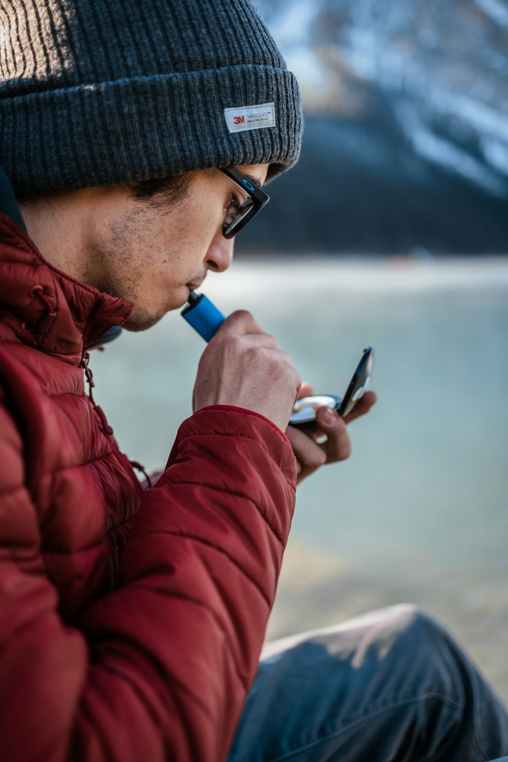 a man in a beanie is looking at his cell phone