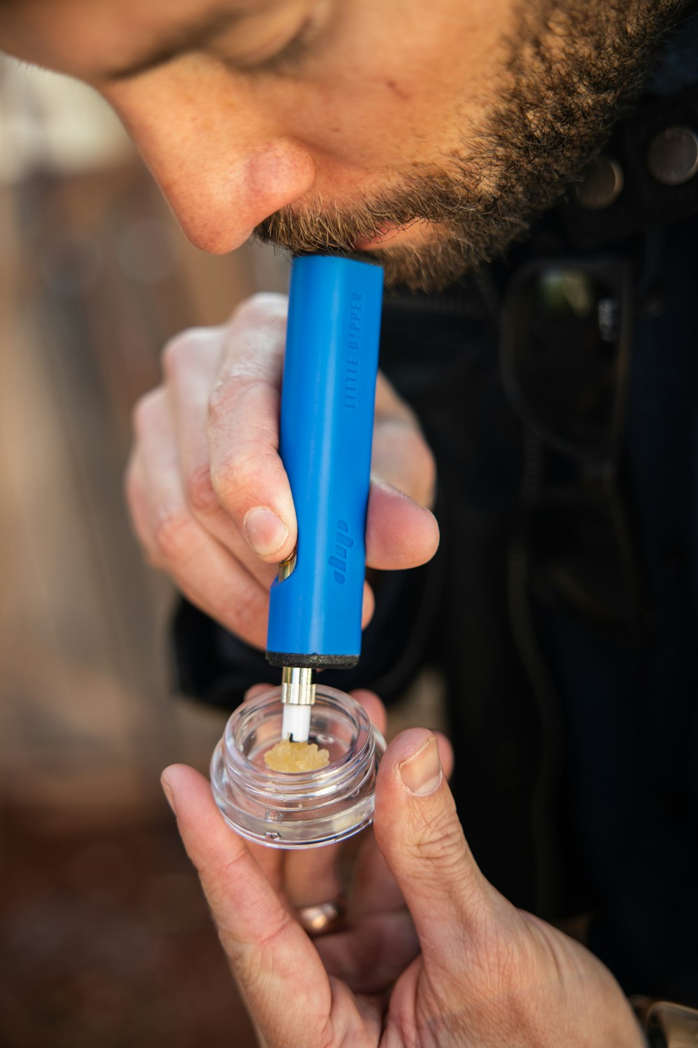 a man holding a small blue object in his hand